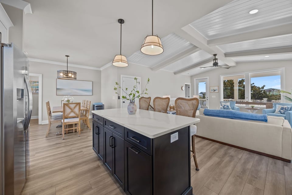 Bright Coastal Kitchen w/ Stainless Steel Refrigerator, Built-In Microwave, Electric Range Oven, Dishwasher, Large Island Seating, Pendant Lighting, and Natural Light