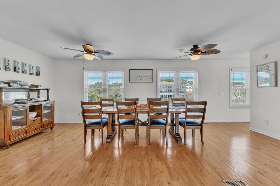 Gather around your spacious dining table with coastal views streaming through bright windows, creating perfect moments for meals together.