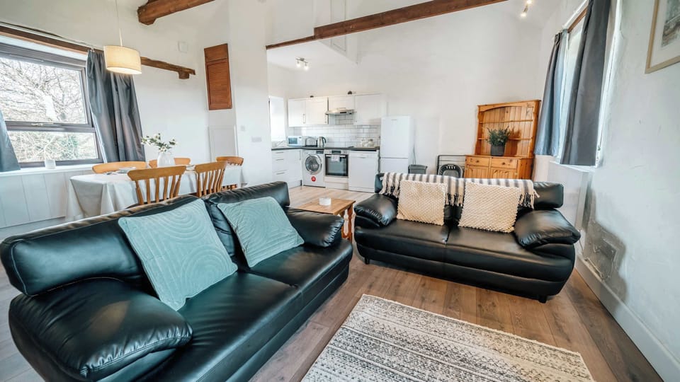 Unwind under original timber beams in our airy, open-plan lounge—ideal for cozy movie nights on the Smart TV or a quiet afternoon with a board game.