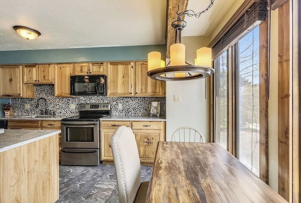 Cook your favorite meals in this warm rustic kitchen with modern appliances and natural light streaming through windows.