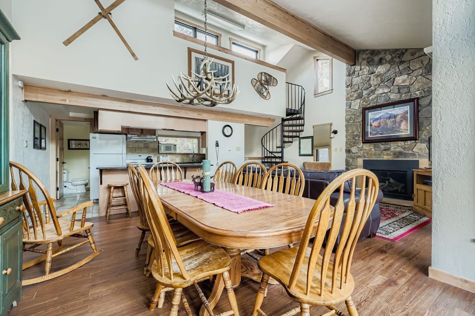 Gather around this rustic dining table beneath soaring beams and antler chandelier, where your mountain memories begin.