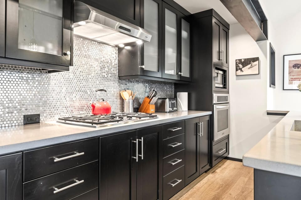 Full-length cabinetry, tile backsplash, and streamlined design offer both beauty and utility.