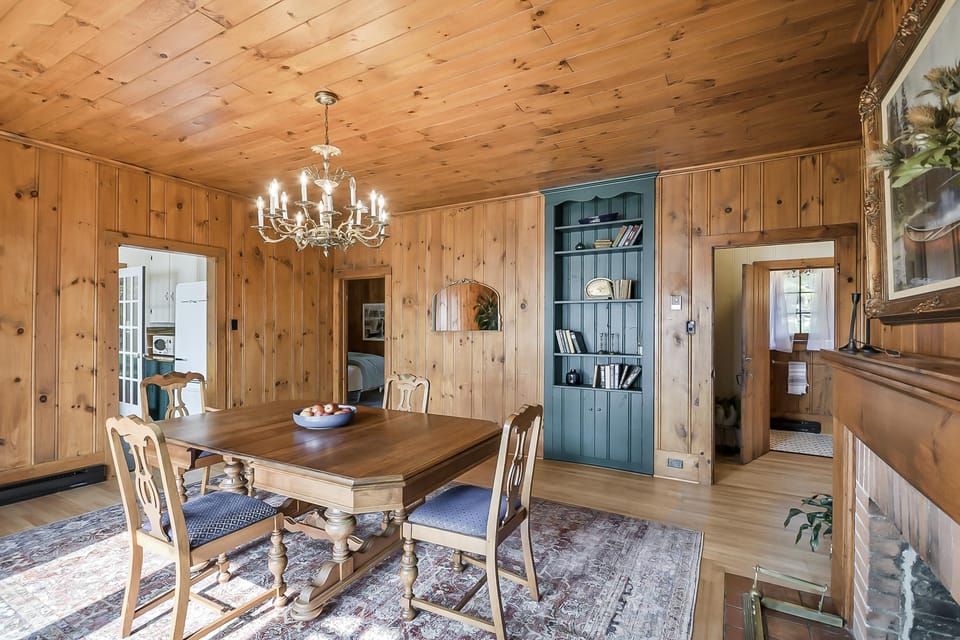 Cozy rustic dining room with charming wood paneling and chandelier