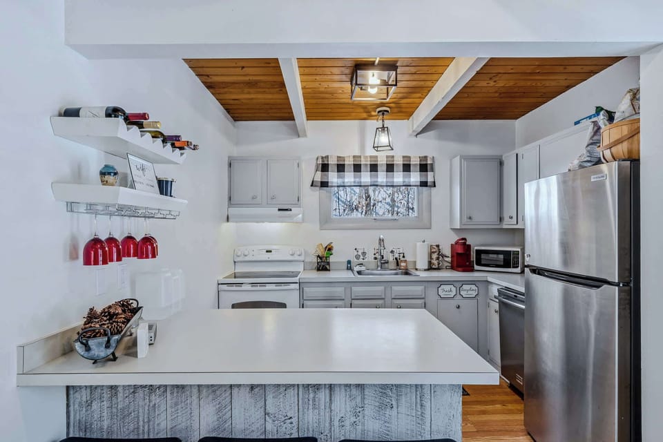 Kitchen with wine rack, hanging stemware, and breakfast bar
