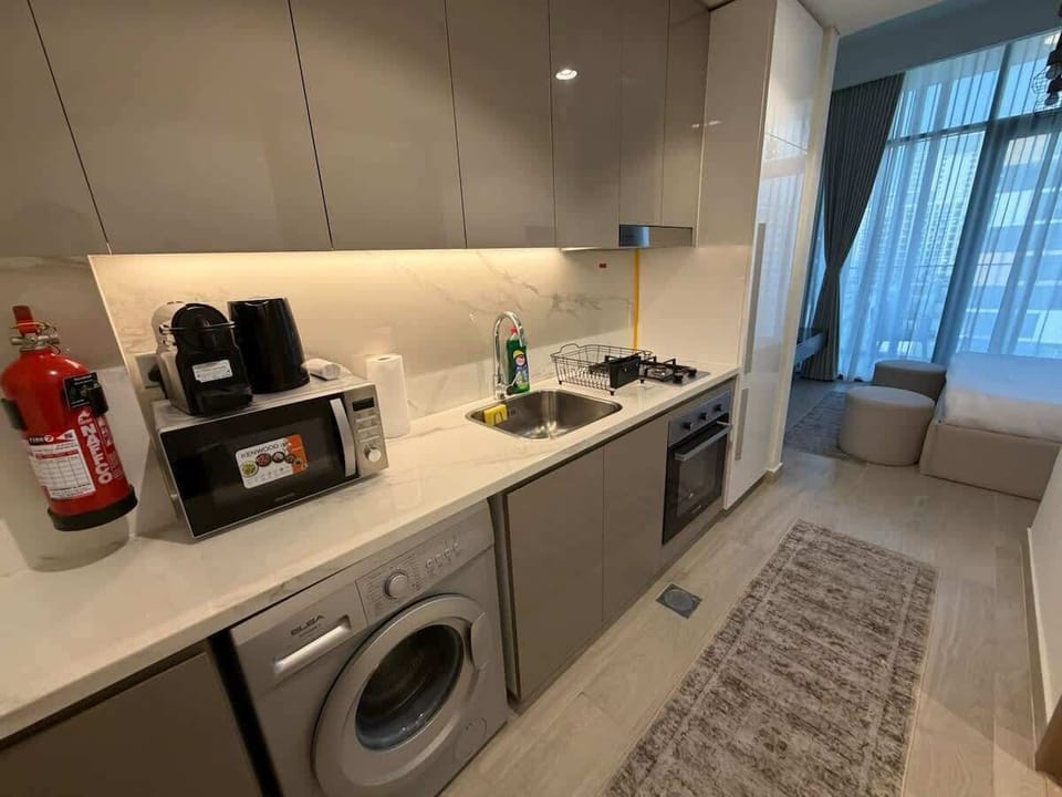 Kitchenette with washing machine and cooking essentials