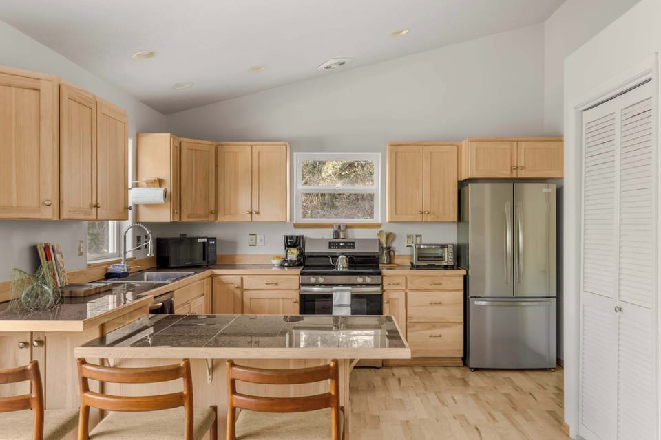 Bright open kitchen with modern appliances, island seating & everything you need for easy vacation meals.