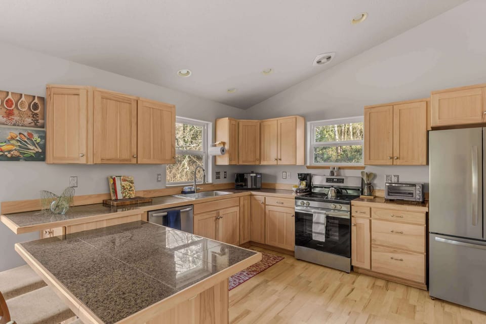 Fully equipped kitchen with stainless appliances, ample counter space & natural light.