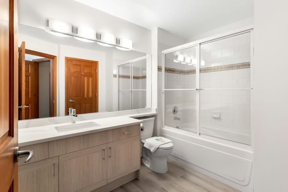Unwind with a spacious bath-shower combo and wide mirror.