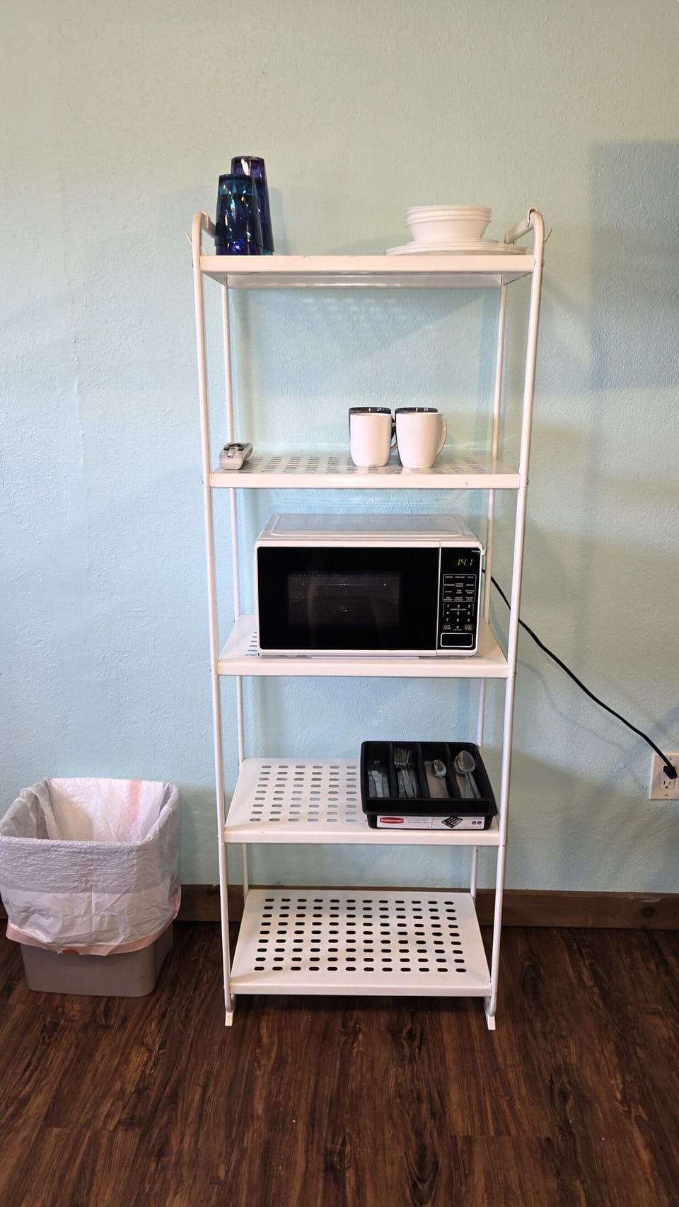 A microwave and basic cookware/kitchenware are provided.