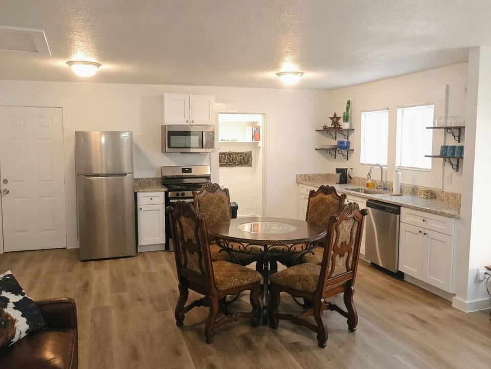 coffee maker, kitchen, oven, refrigerator, stovetop, dining table, microwave