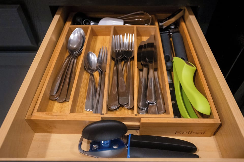 Fully stocked kitchen with utensils organized in drawers for convenient meal prep.