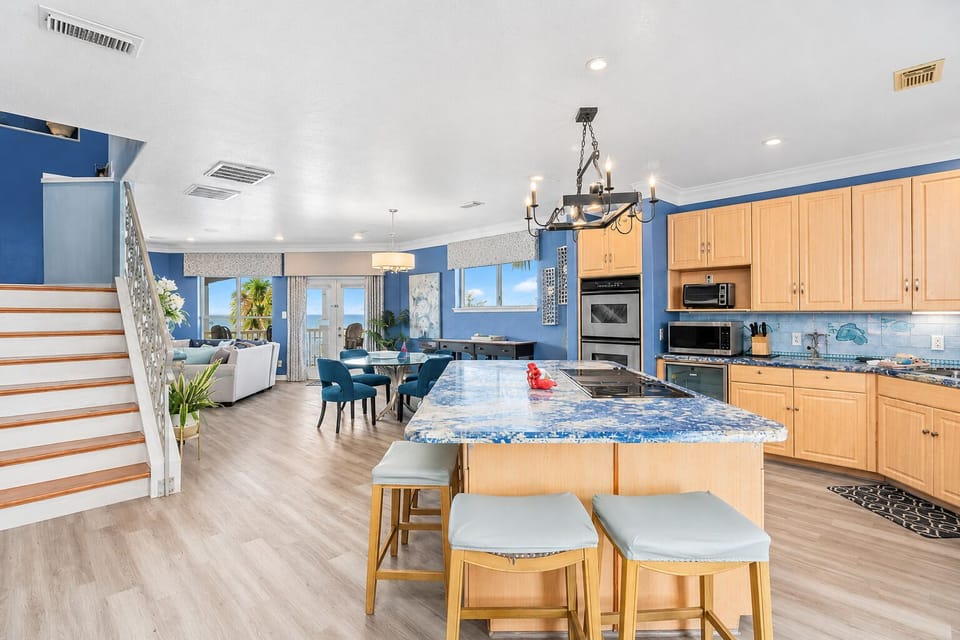 Open-concept kitchen with granite island seating, stainless steel appliances and easy flow into the dining and living areas, ideal for family meals and group gatherings.