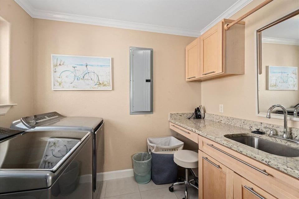Laundry room with washer and dryer for extended Galveston beach stays.