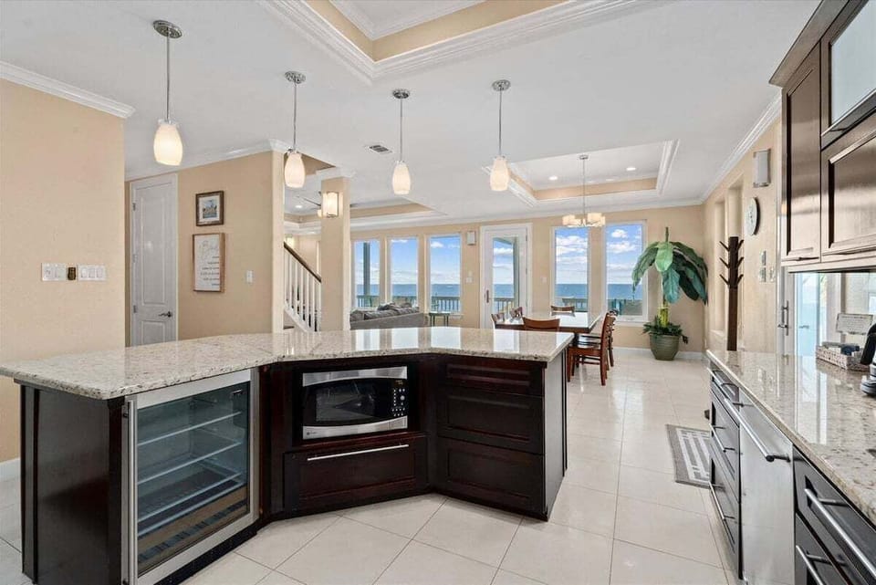 Modern kitchen with large island, stainless appliances, and open coastal layout in this Galveston bayfront home.