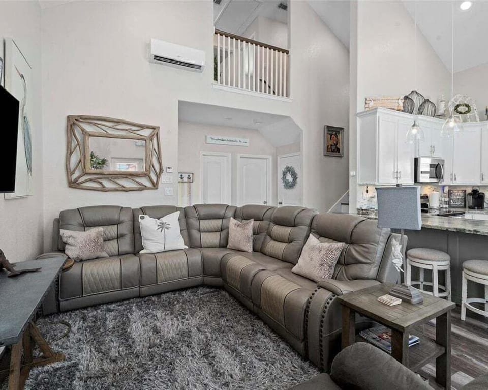 Spacious sectional seating area with open view to the kitchen and loft, designed for group gatherings and family movie nights.