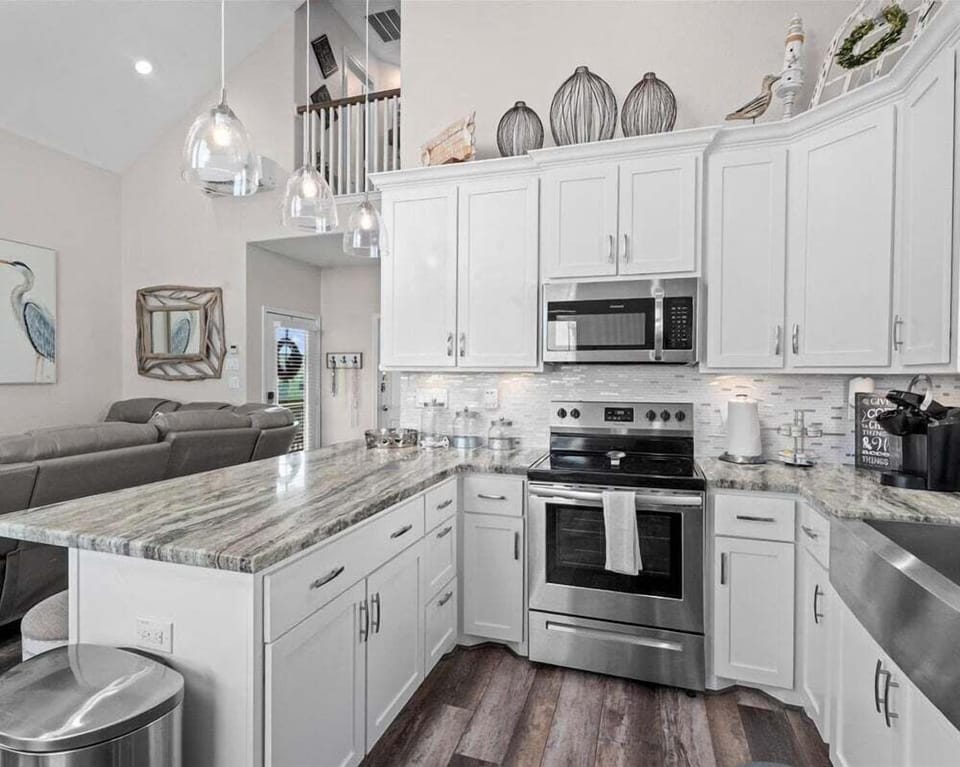 Spacious kitchen with island seating, stainless steel appliances, and open layout for cooking and socializing.