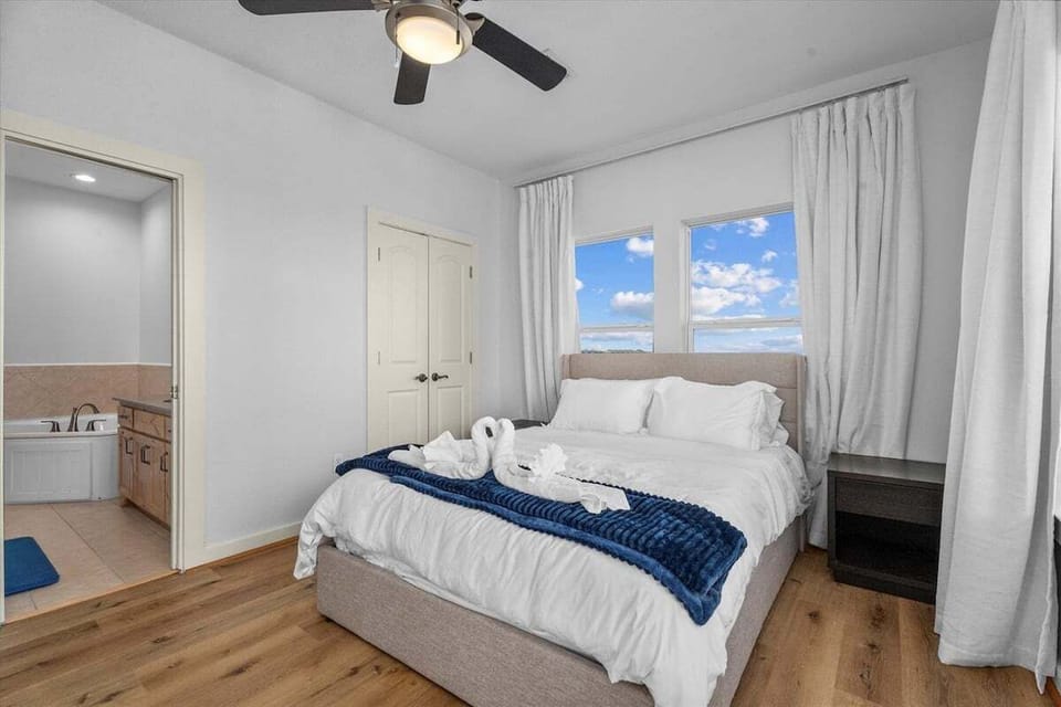 Comfortable bedroom with plush bedding, bright windows, and peaceful beach vibes.