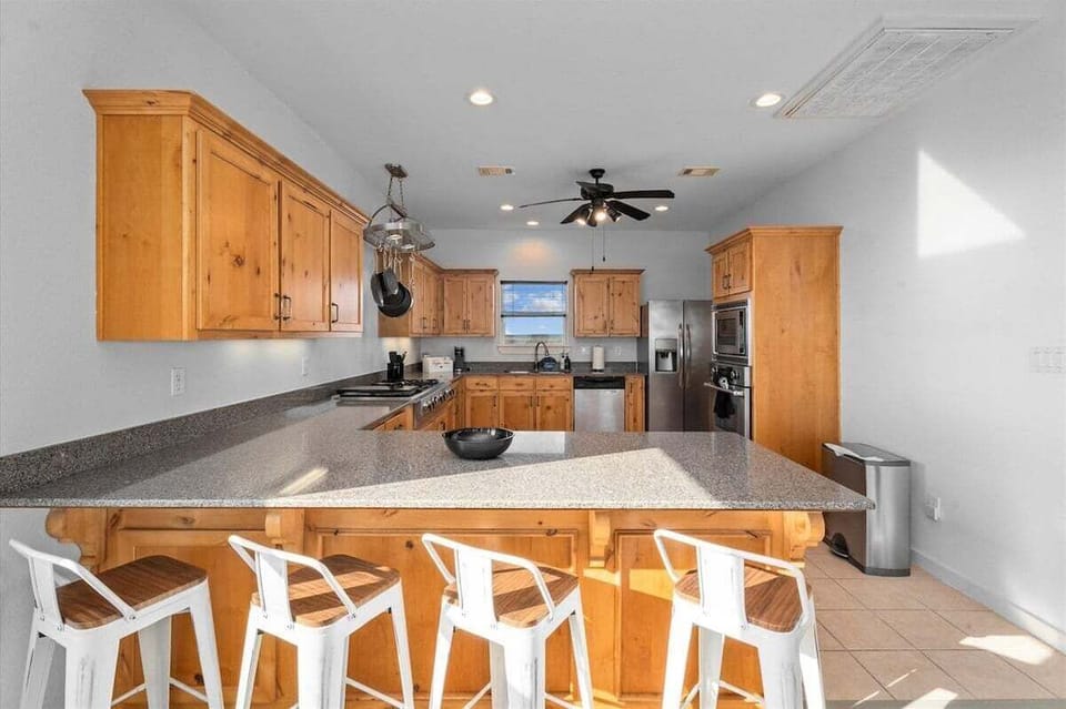 Fully equipped kitchen with breakfast bar, bar stools, and ample counter space for entertaining.