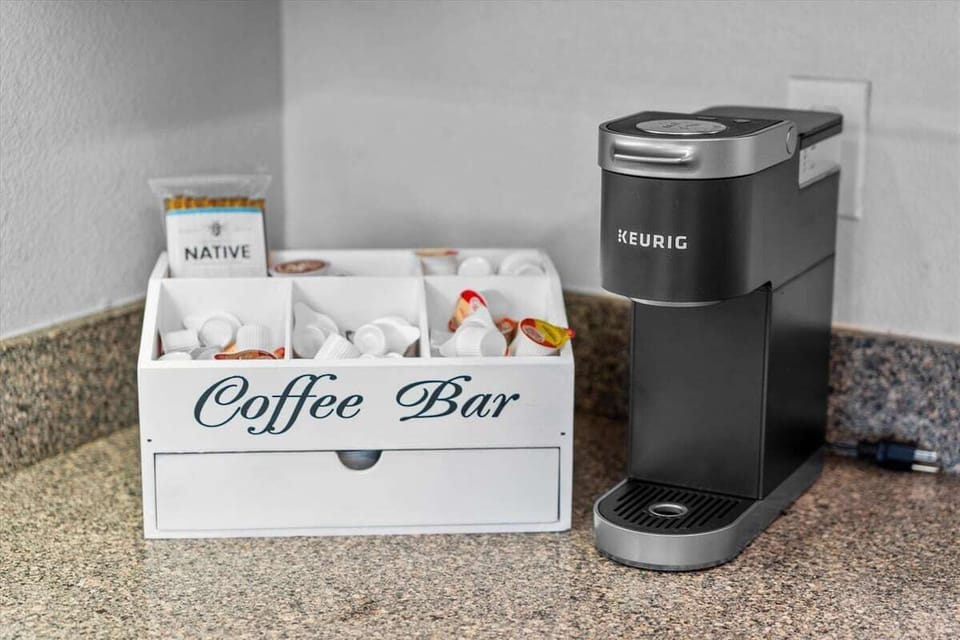 Coffee bar station with Keurig machine and essentials, perfect for morning coffee by the beach.