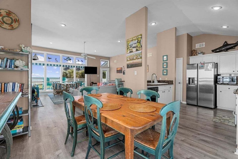 Spacious dining area with large table seating and open-concept floor plan. Conveniently located adjacent to the kitchen for easy meal service.