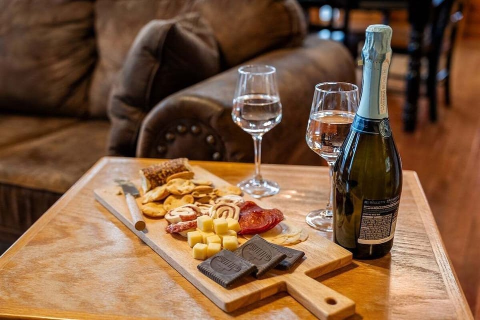 Romantic cabin dining setup with wine, charcuterie board, and rustic Smoky Mountain lodge ambiance.