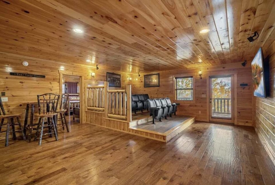 A private lodge theater room featuring tiered seating and a warm wood interior. Perfect for movie nights, game-day watch parties, and unwinding together in a cozy, rustic setting.