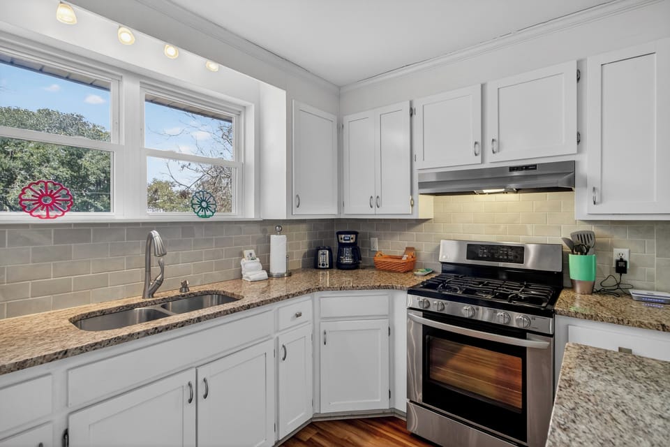 Bright, fully equipped kitchen with granite counters—perfect for cooking and serving up coastal feasts.