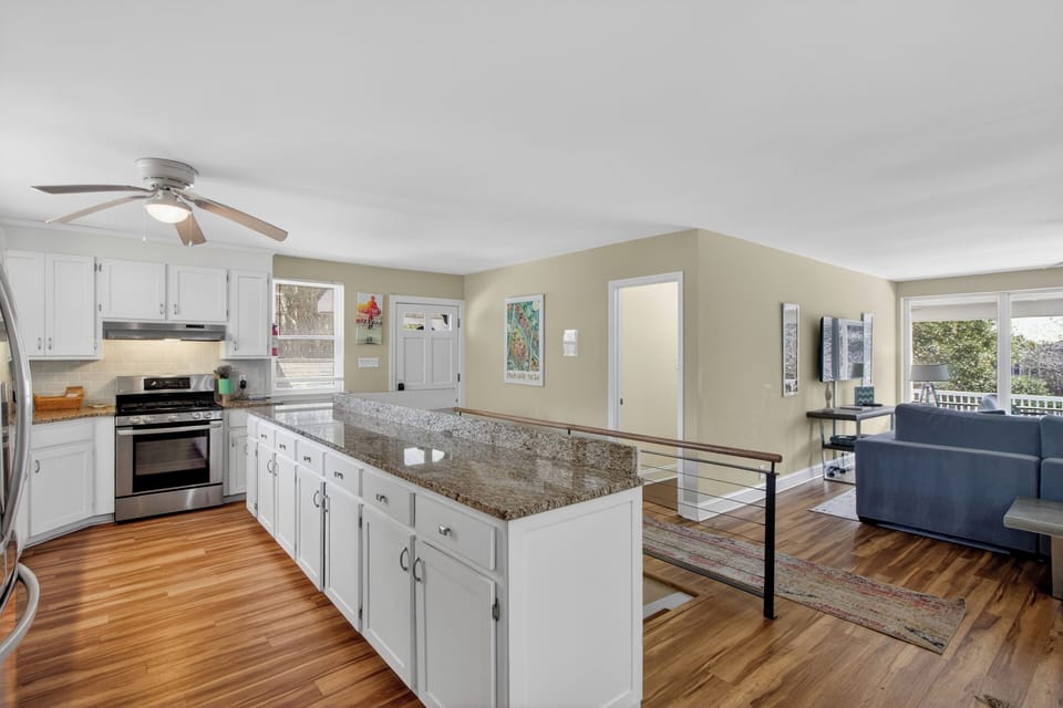 Bright, fully equipped kitchen with granite counters—perfect for cooking and serving up coastal feasts.