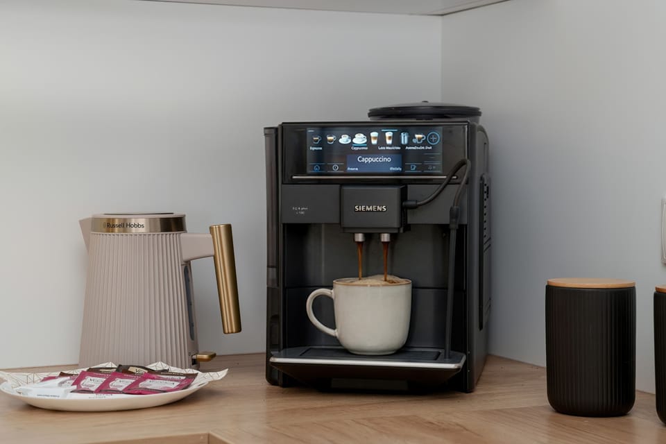 A coffee machine and an electric kettle are neatly placed on the kitchenette counter. This setup promises a perfect start to the day for coffee lovers staying in the apartment.