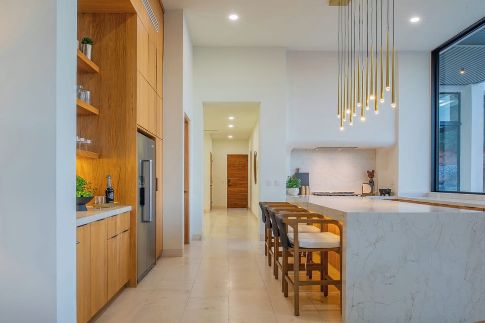 Your culinary dreams come alive in this stunning modern kitchen with sleek marble island, warm wood cabinetry, and designer lighting.
