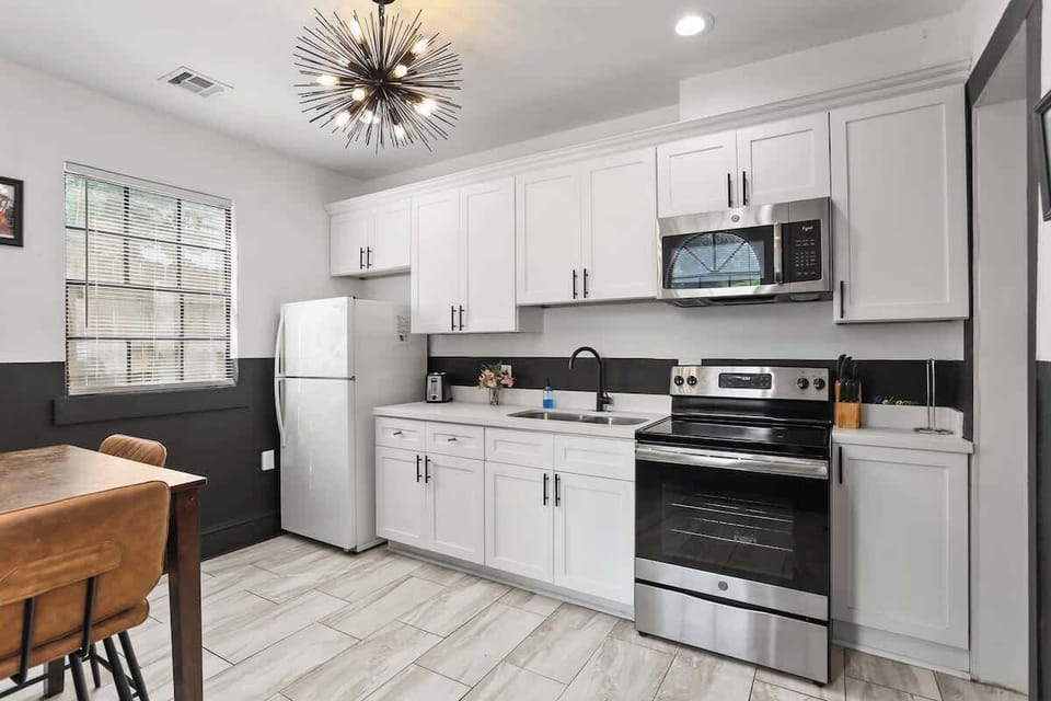 Sleek, fully equipped kitchen featuring modern appliances, generous counter space, and stylish lighting—ideal for cooking, dining, or gathering between adventures.