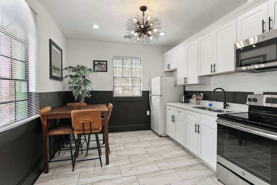 Bright, modern kitchen with full-size appliances, ample cabinet space, and a cozy dining nook—perfect for morning coffee or meals at home under stylish lighting.