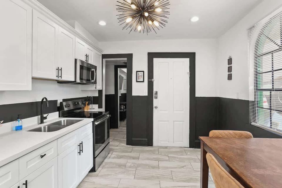 Modern, fully equipped kitchen with stainless steel appliances, ample counter space, and a cozy dining table—perfect for cooking in or enjoying a relaxed meal before heading out.