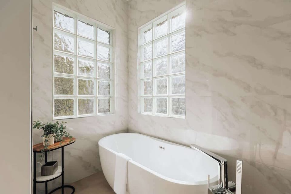 Soak away your worries in this elegant freestanding tub, surrounded by luxurious marble and natural light from dual windows.