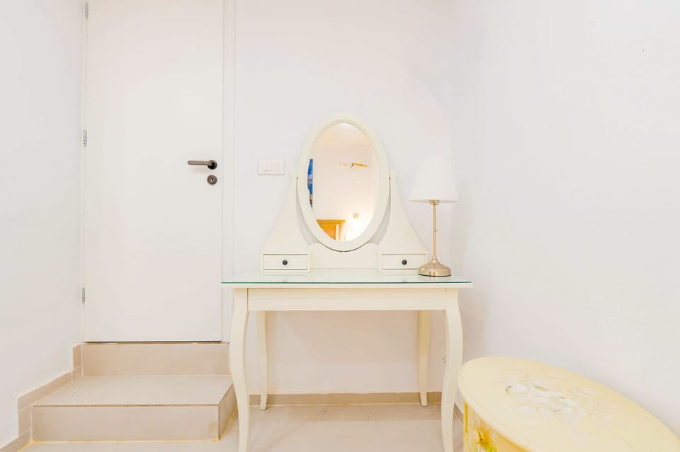 Peaceful vanity corner with elegant island-inspired touches
Comfortable bedroom with warm ambient lighting
Spacious bedroom retreat with calming neutral tones
Minimalist twin bedroom with soft lighting and clean design
