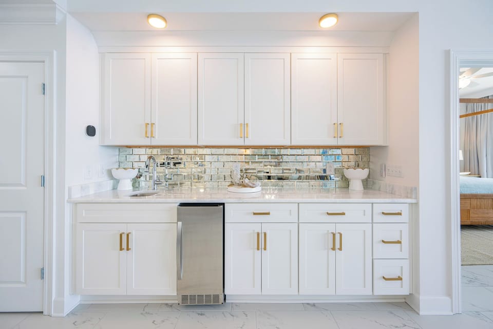 Reflective backsplash glimmers above the wet bar while you prepare fresh snacks for your family