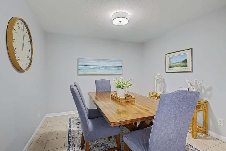 Gather around this elegant dining table for memorable meals together, with coastal artwork creating a serene backdrop for your conversations.