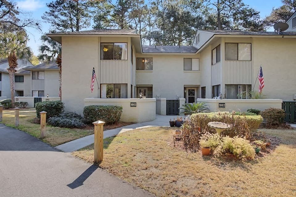 Modern townhome complex with landscaped grounds, mature trees, and convenient location in a peaceful residential community.