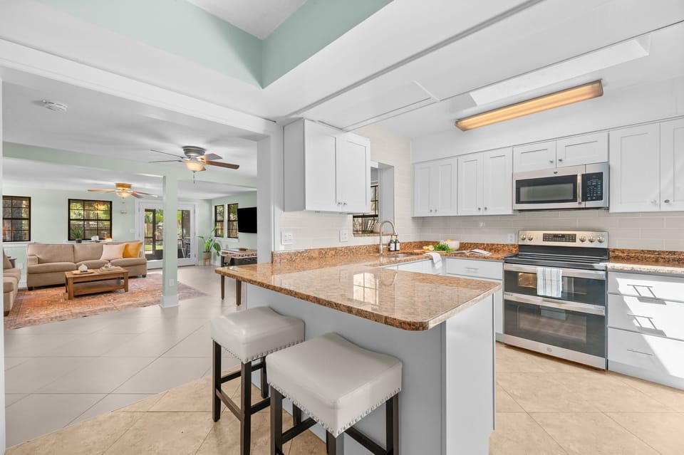 Bright dining area with seating for shared meals, complemented by a fully equipped kitchen complete with essential utensils, cookware, and appliances—perfect for easy meal prep and comfortable group dining
