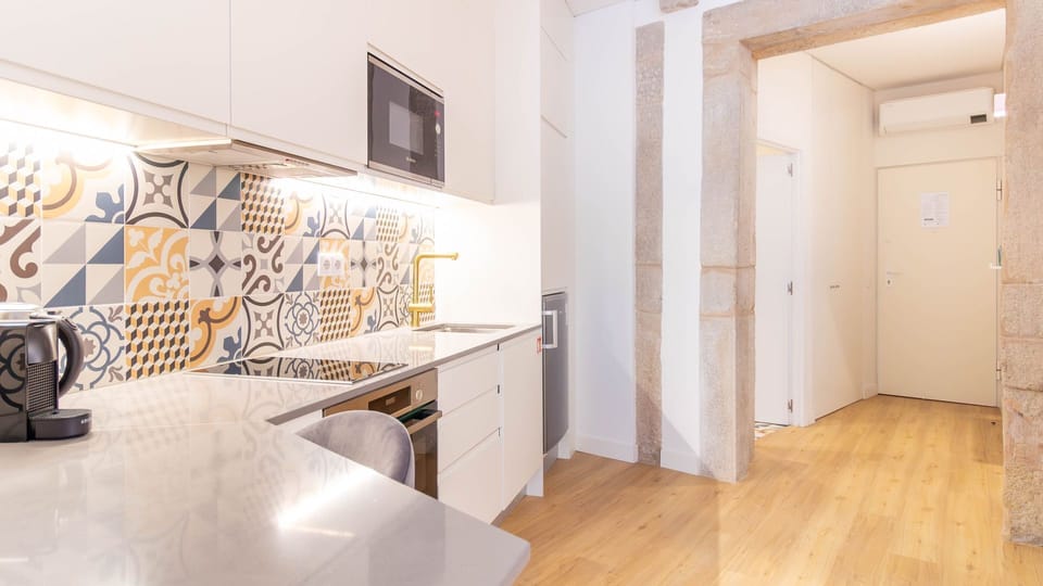 Modern kitchenette with oven, Nespresso machine, kettle, and stylish Portuguese tile backsplash.
#Kitchenette #Nespresso #PortugueseTiles #DesignDetails #SelfCatering #PortoStay