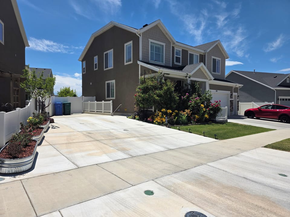 Clean front view of the single-family home with large driveway and lawn.