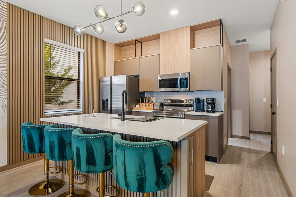 Modern kitchen with a large island and teal velvet bar stools