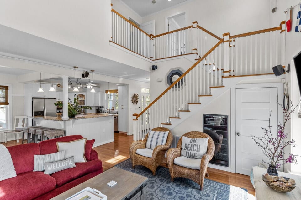 Gather and relax in this spacious open-concept living room with high ceilings and inviting coastal-style seating