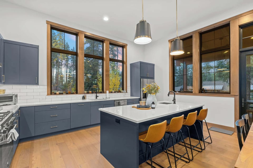 Bright chef’s kitchen with oversized island and bar seating for gathering.