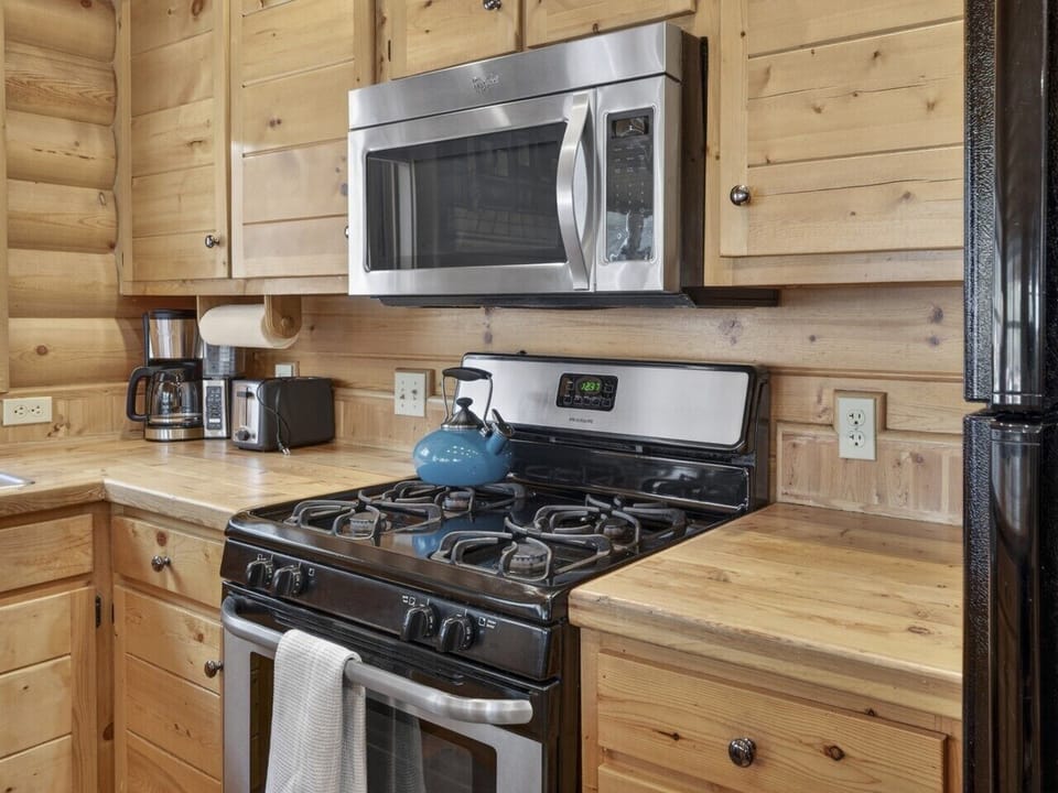 Kitchen | Gas Range & Coffee Maker | Wood Cabinetry & Island Seating