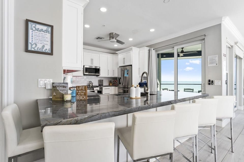 The bright, modern kitchen flows seamlessly to the beachfront balcony, letting you cook, entertain, and enjoy spectacular ocean views all at once.