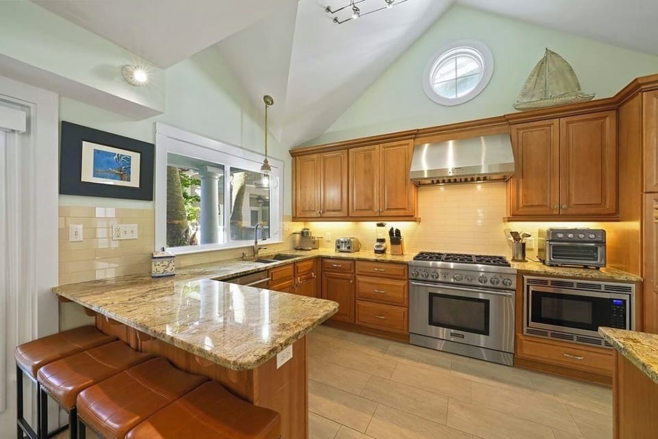 Main House 1st Floor - Gourmet kitchen featuring a premium Thermador gas range, spacious countertops, and everything needed to prepare meals for your group. Perfect for family dinners, entertaining, and gathering after a day at the beach.
