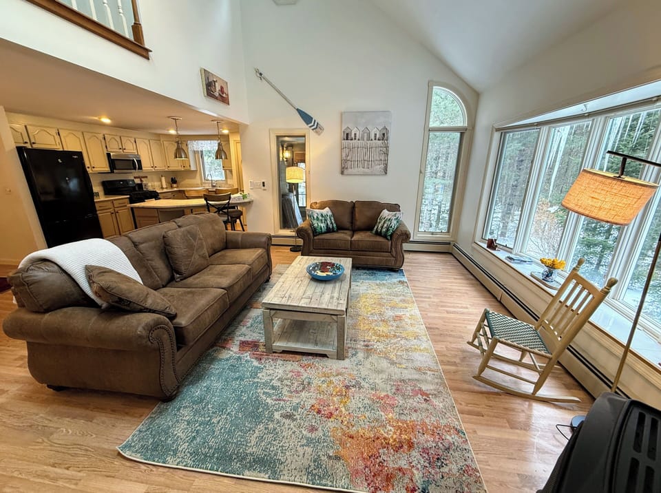 Main Level Living area sits adjacent to the dining and kitchen areas. This room offers lots of natural light, a gas stove and a smart TV.