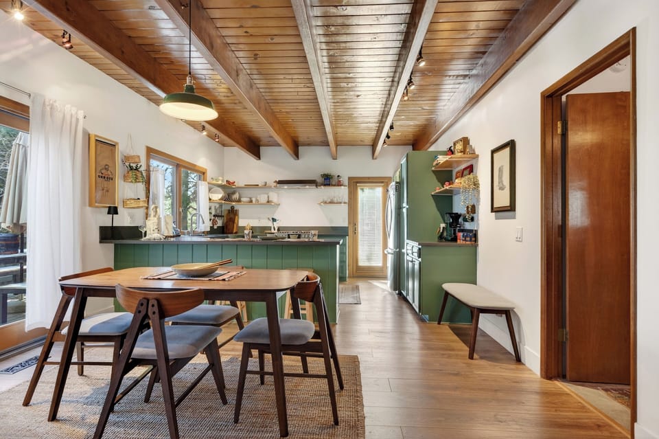 Bright, open kitchen + dining with cedar-beam ceilings, bar seating, and everything you need to cook and gather.