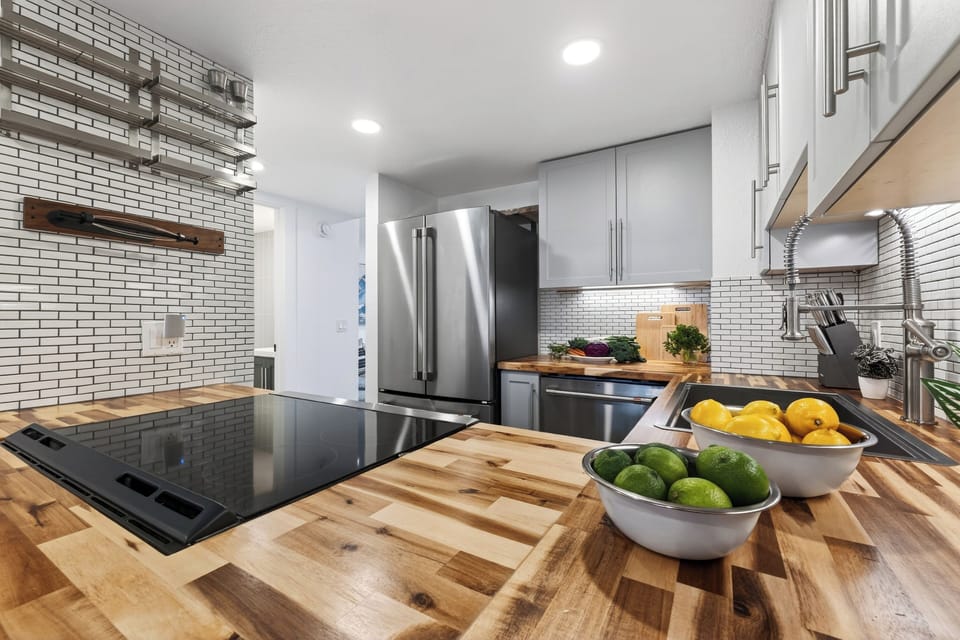 Sleek, fully equipped kitchen with butcher-block counters and modern finishes.